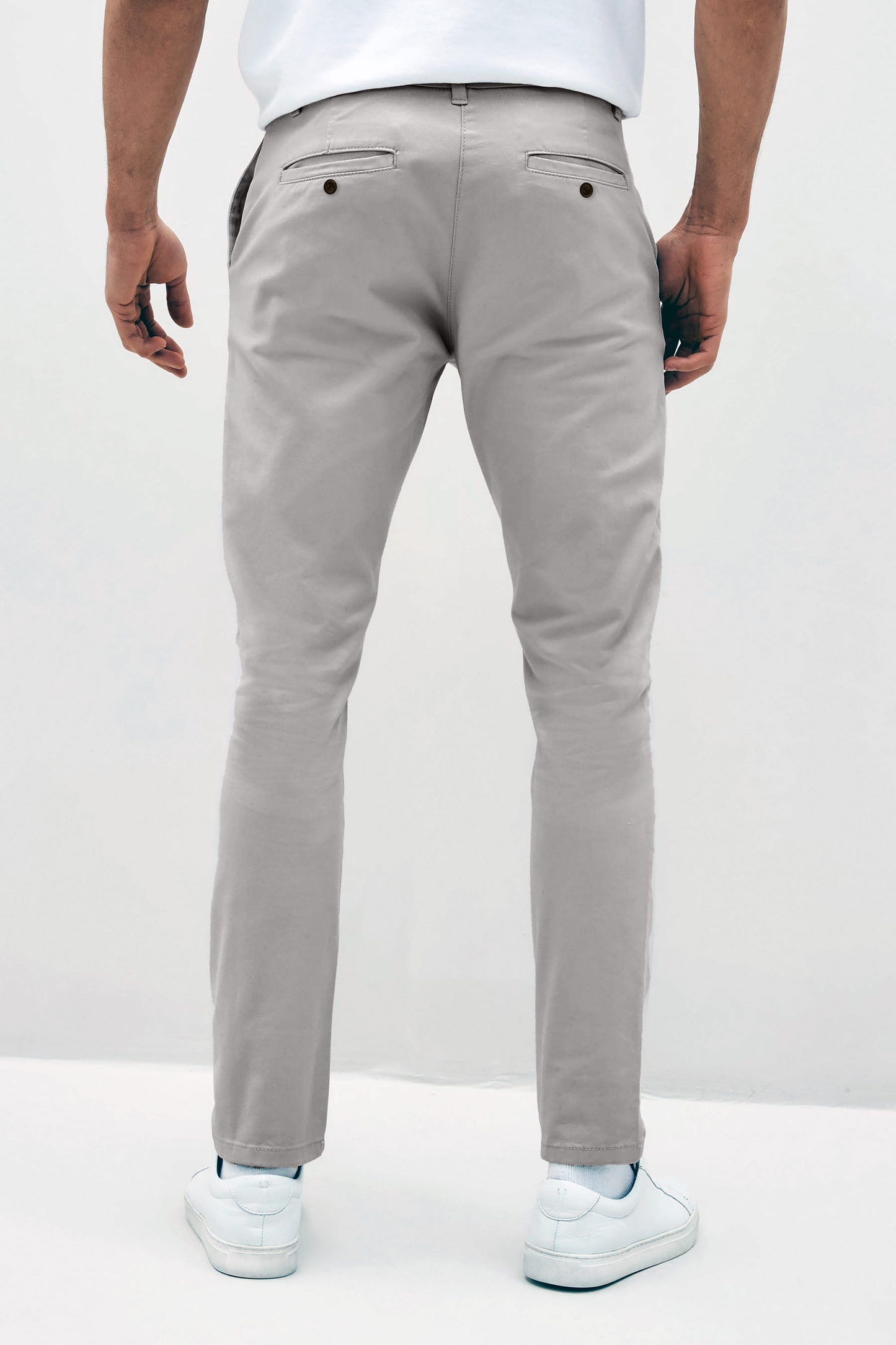 Mens Silver Grey chinos with front slanted pockets, jetted back pockets. zip fly fastening and brown horne buttons on the waistband and back pockets, the fit is a slim fit, this is worn with a white tee and white unbranded trainers