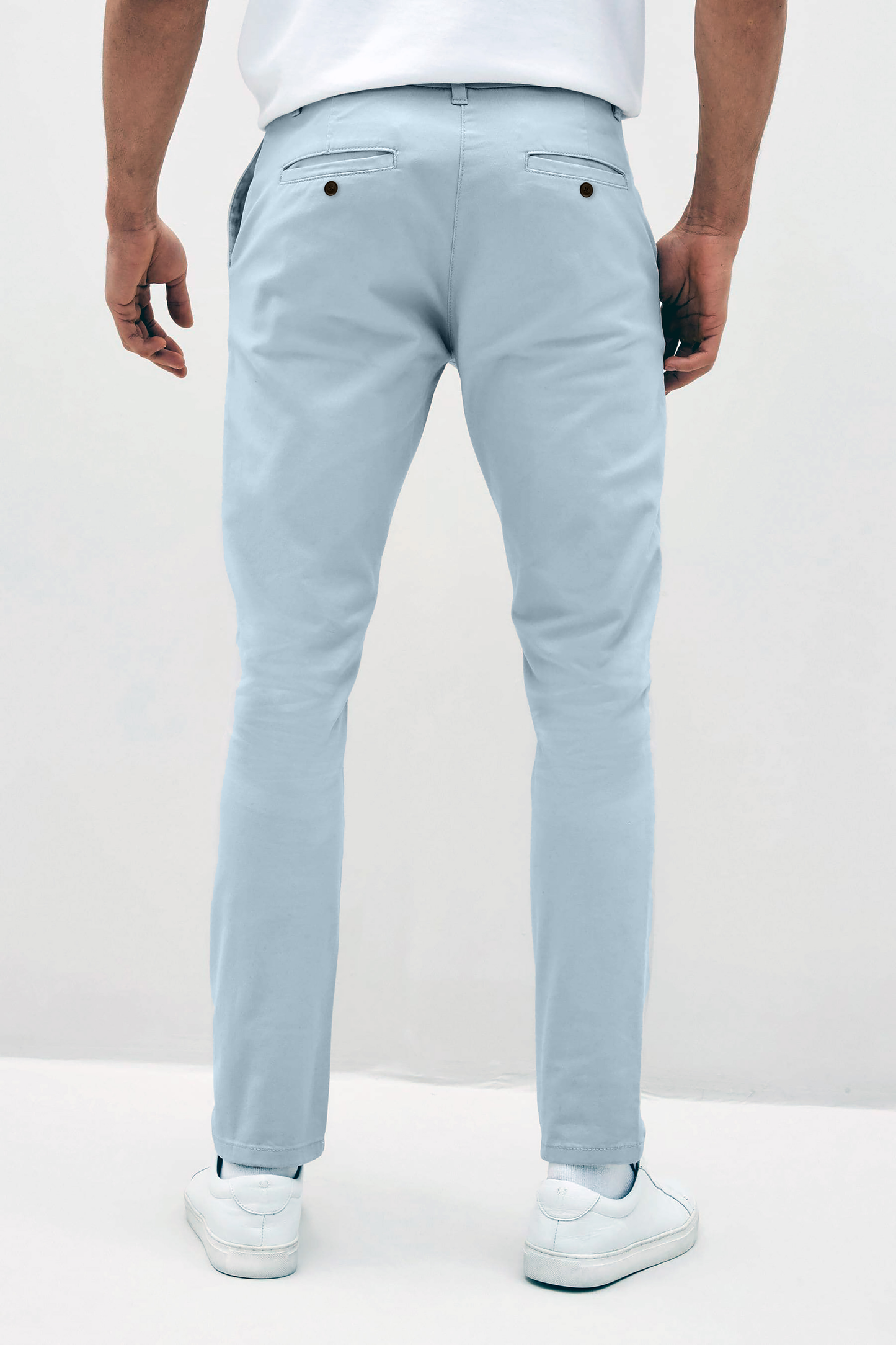 Mens sky Blue chinos with front slanted pockets, jetted back pockets. zip fly fastening and brown horne buttons on the waistband and back pockets, the fit is a slim fit, this is worn with a white tee and white unbranded trainers
