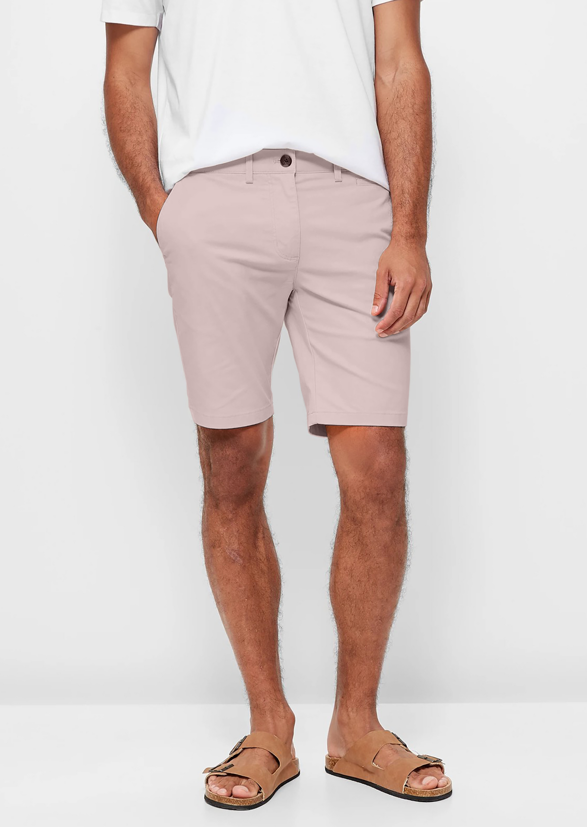 Mens pale pink chinos shorts with front slanted pockets, jetted back pockets. zip fly fastening and brown horne buttons on the waistband and back pockets, the fit is a slim fit, this is worn with a white tee and white t-shirt